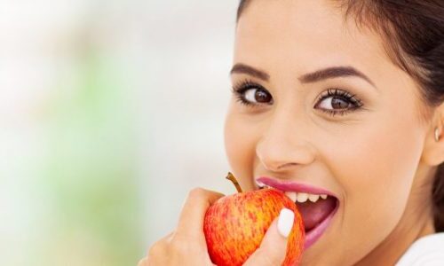 Photo of a woman eating an apple