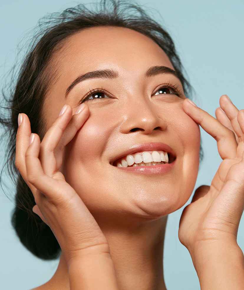 Photo of a smiling woman touching her cheeks