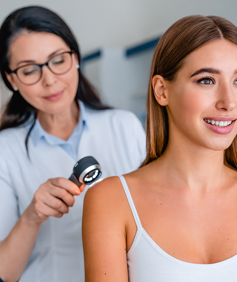 Photo of a female patient being looked at by a dermatologist