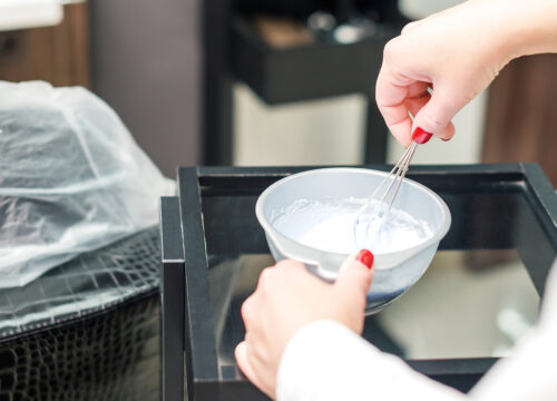 Photo of a hair colorist mixing up hair dye for a client