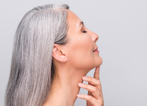 Photo of an older woman touching the area below her chin